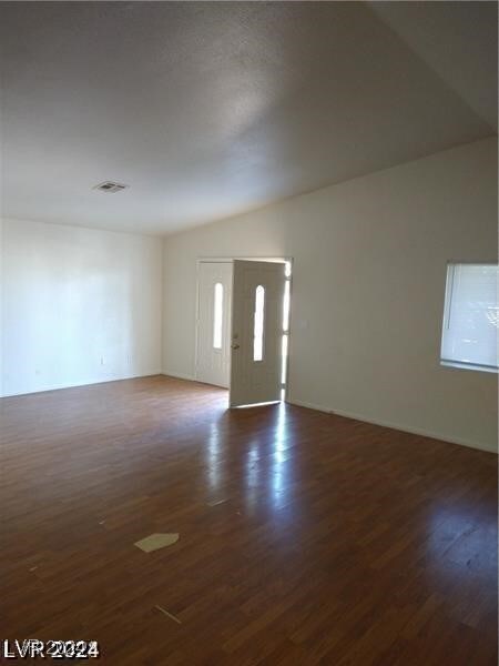 foyer featuring dark wood-type flooring and vaulted ceiling