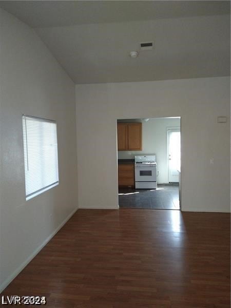 unfurnished living room featuring lofted ceiling and dark hardwood / wood-style flooring