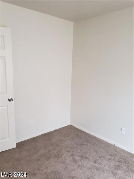 unfurnished room featuring dark carpet