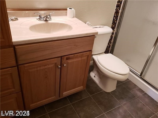 bathroom with vanity, an enclosed shower, toilet, and tile patterned flooring