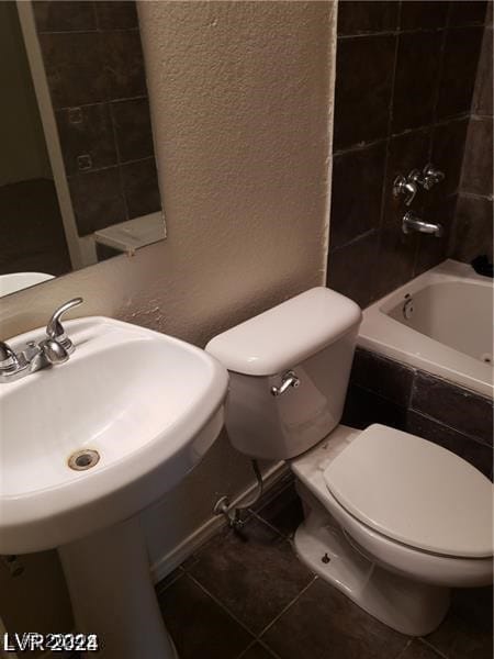 full bathroom featuring tiled shower / bath, sink, toilet, and tile patterned flooring