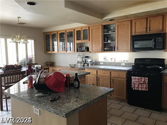 kitchen with black appliances, a center island, pendant lighting, an inviting chandelier, and a raised ceiling