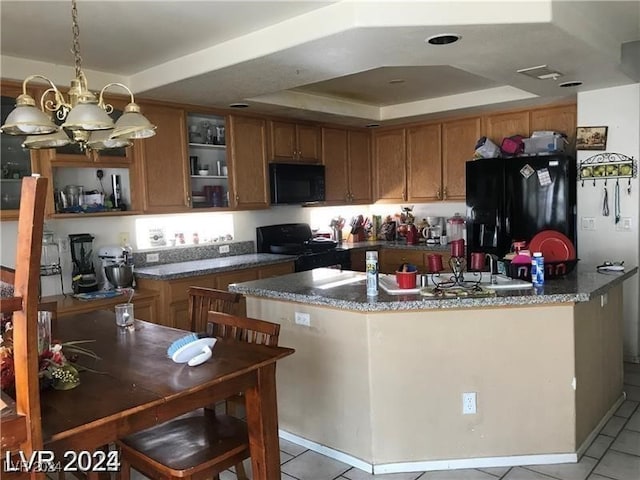 kitchen with black appliances, decorative light fixtures, an inviting chandelier, light tile patterned floors, and a raised ceiling