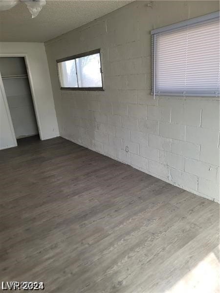 unfurnished bedroom with hardwood / wood-style floors, a textured ceiling, and a closet