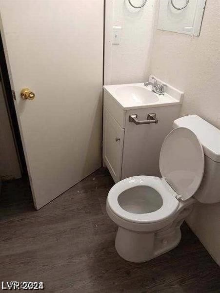 bathroom with vanity, hardwood / wood-style flooring, and toilet