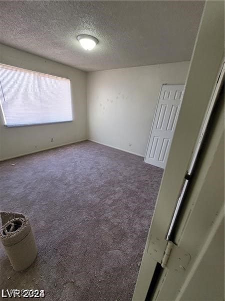 carpeted spare room with a textured ceiling