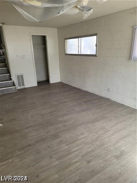 unfurnished bedroom with a textured ceiling and dark wood-type flooring