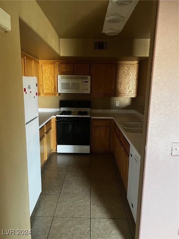 kitchen featuring sink, white appliances, tile patterned floors, and a wall mounted air conditioner