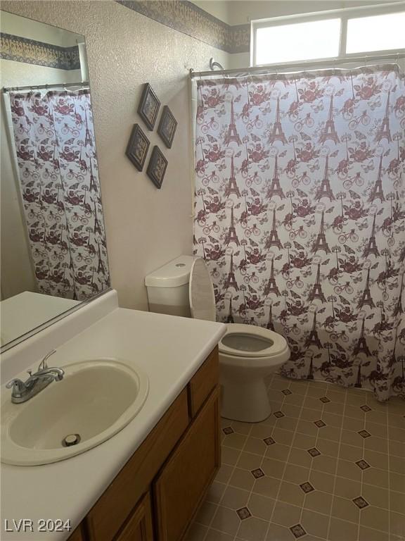 bathroom featuring vanity, toilet, and tile patterned flooring