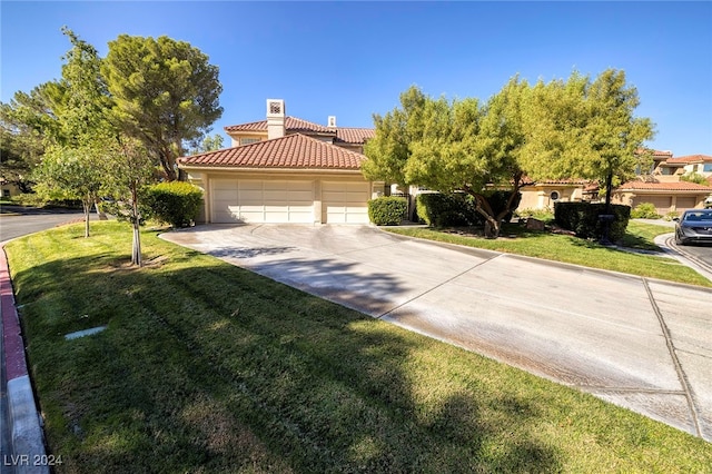 view of front of property featuring a garage and a front lawn