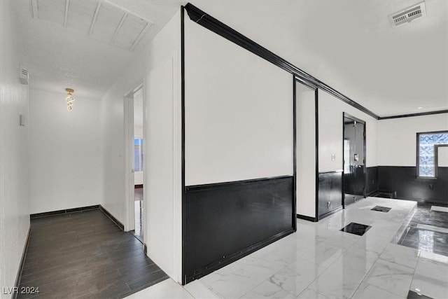 hallway with hardwood / wood-style floors and crown molding