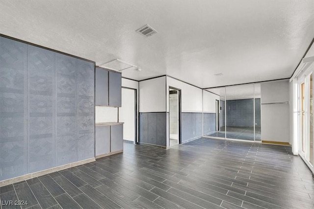 unfurnished room with a textured ceiling and dark hardwood / wood-style floors