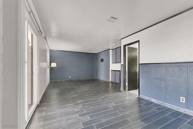 unfurnished room featuring a textured ceiling and dark hardwood / wood-style floors