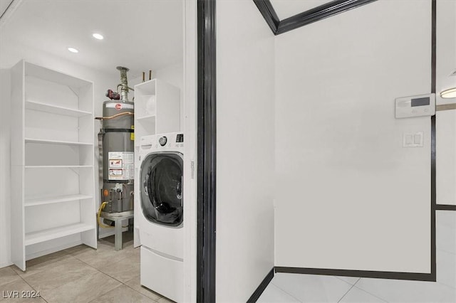 laundry room featuring secured water heater, light tile patterned floors, washer / dryer, and ornamental molding