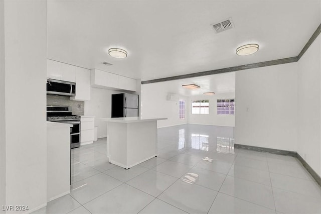 kitchen featuring white cabinetry, stainless steel appliances, light tile patterned floors, and tasteful backsplash