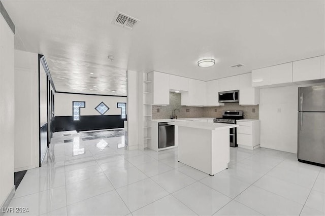 kitchen featuring a center island, stainless steel appliances, light tile patterned floors, backsplash, and white cabinets