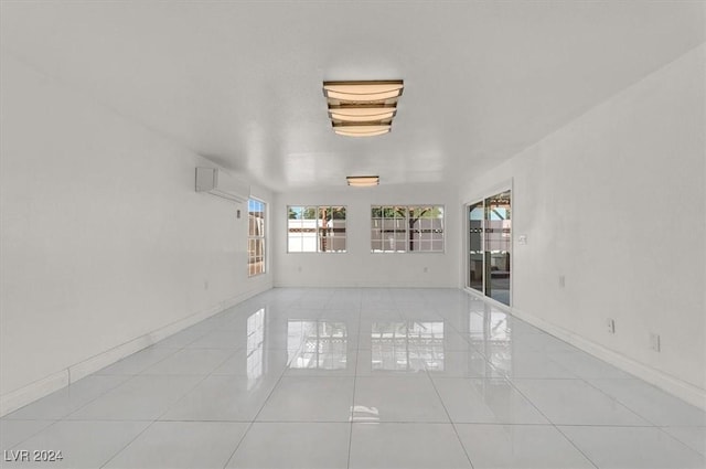 tiled empty room featuring a wall unit AC