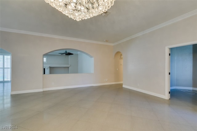 empty room featuring ceiling fan with notable chandelier and crown molding