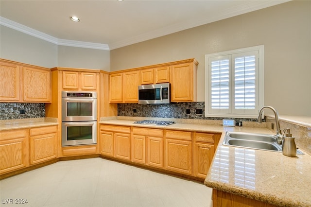 kitchen with appliances with stainless steel finishes, sink, light stone countertops, ornamental molding, and decorative backsplash