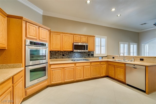 kitchen with sink, appliances with stainless steel finishes, crown molding, and decorative backsplash