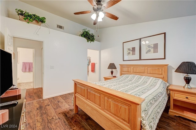 bedroom with dark wood-type flooring, vaulted ceiling, ensuite bathroom, and ceiling fan