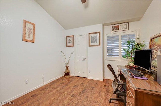 office with baseboards, wood finished floors, and vaulted ceiling