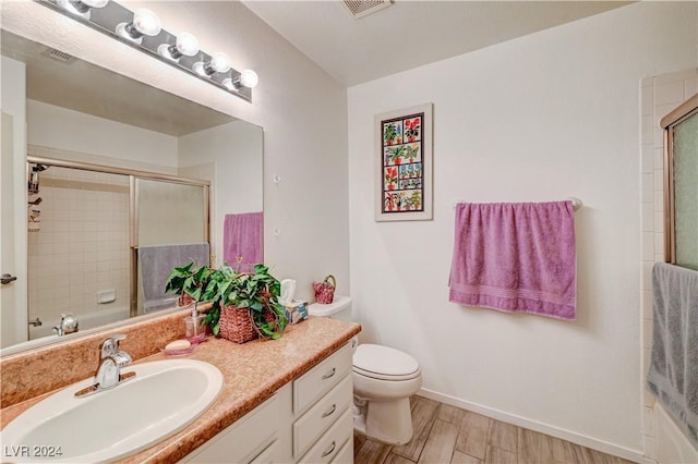 full bathroom with visible vents, wood finished floors, vanity, baseboards, and toilet