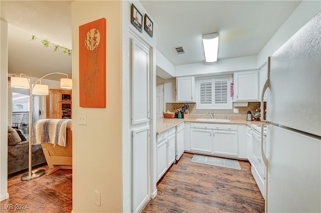 kitchen featuring dark hardwood / wood-style flooring, white cabinetry, sink, and white appliances