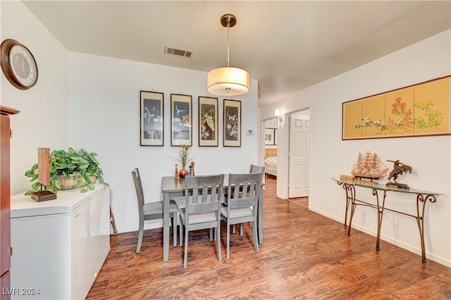 dining area featuring baseboards, visible vents, and wood finished floors