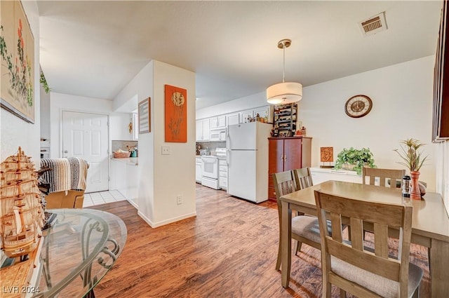 dining space featuring visible vents and light wood-style flooring