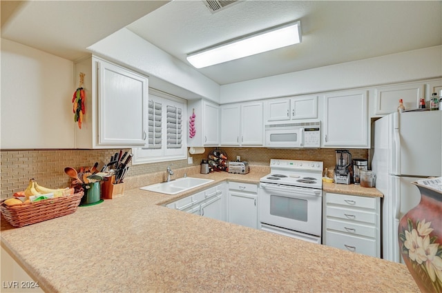 kitchen featuring decorative backsplash, white cabinets, sink, and white appliances