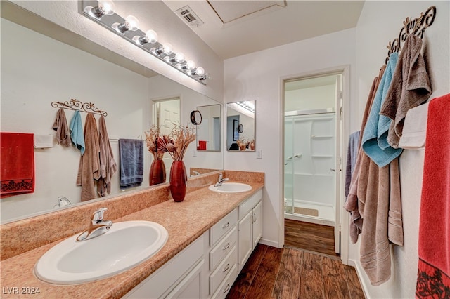 bathroom featuring a shower with door, hardwood / wood-style flooring, and vanity