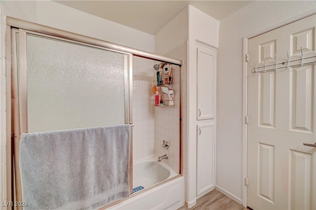 bathroom with enclosed tub / shower combo and wood finished floors