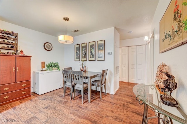 dining room with light wood-style flooring and visible vents