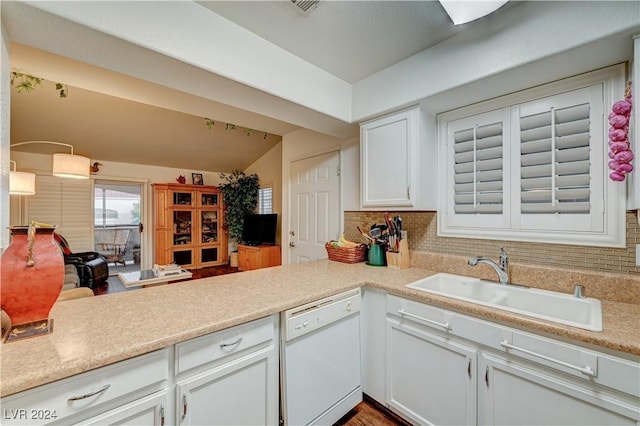 kitchen with white dishwasher, tasteful backsplash, light countertops, a sink, and white cabinets