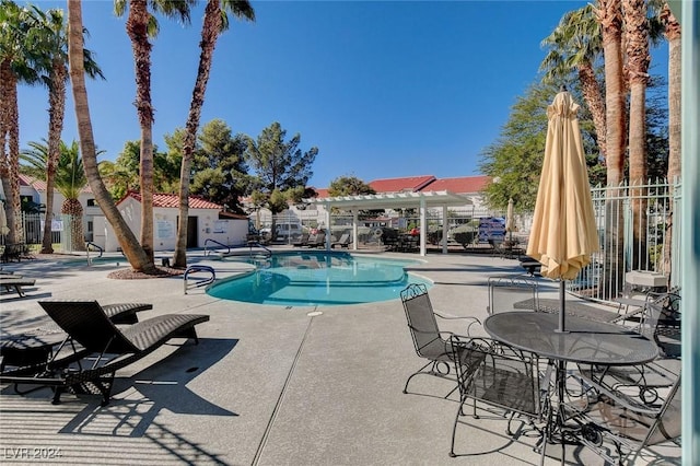community pool with a pergola, fence, and a patio