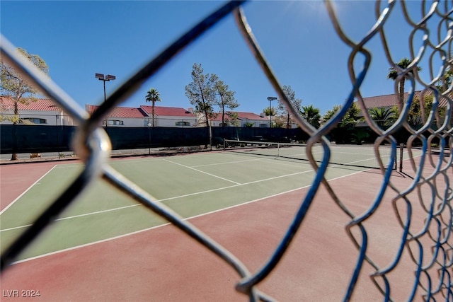 view of tennis court featuring basketball hoop