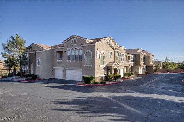 9975 Peace Way Unit 1058, Las Vegas, NV 89147 - view of front of property featuring an attached garage, stucco siding, a residential view, and driveway