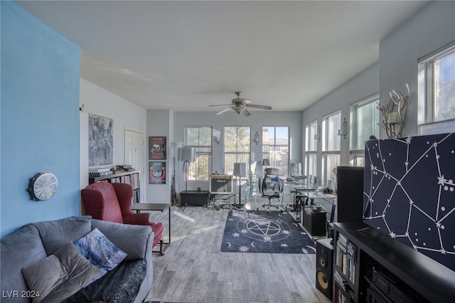 living room featuring ceiling fan, hardwood / wood-style flooring, and plenty of natural light