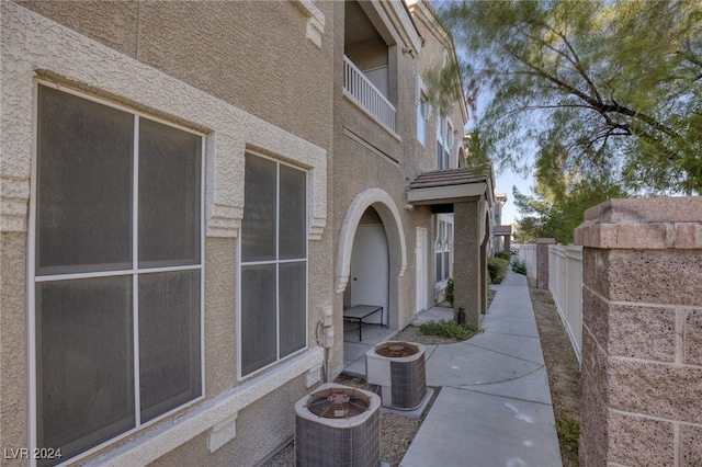 view of side of property featuring a patio area, central AC, and a balcony