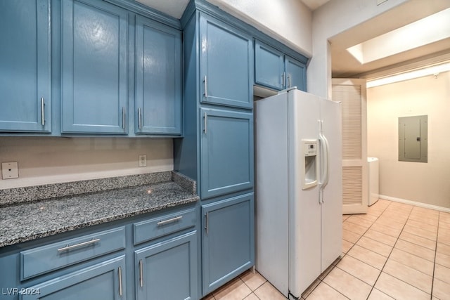 kitchen with blue cabinetry, light tile patterned floors, dark stone countertops, electric panel, and white fridge with ice dispenser