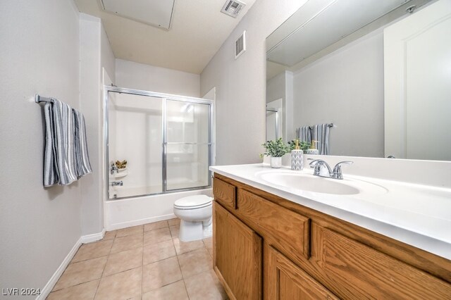 full bathroom featuring tile patterned flooring, toilet, vanity, and combined bath / shower with glass door