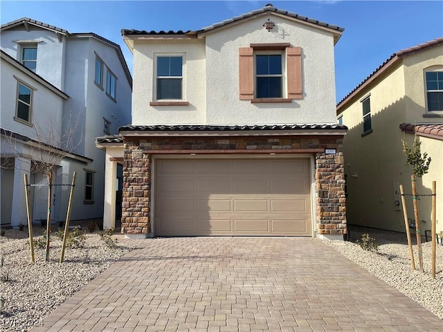 view of front facade with decorative driveway, stone siding, a tile roof, and stucco siding