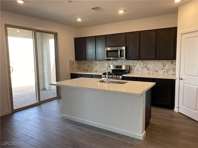 kitchen featuring sink, a wealth of natural light, stainless steel appliances, and an island with sink