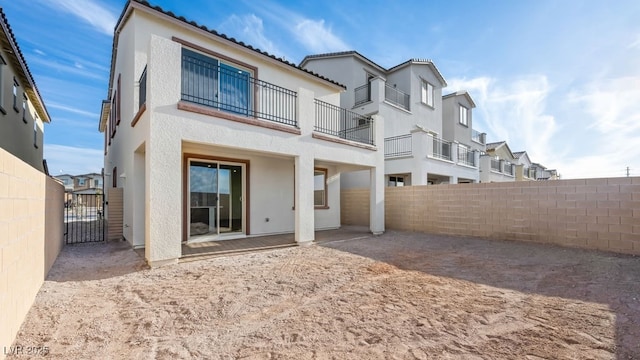 back of property with a tiled roof, a fenced backyard, a residential view, and stucco siding