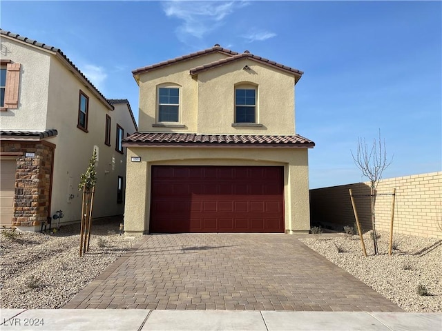 mediterranean / spanish-style home with a garage