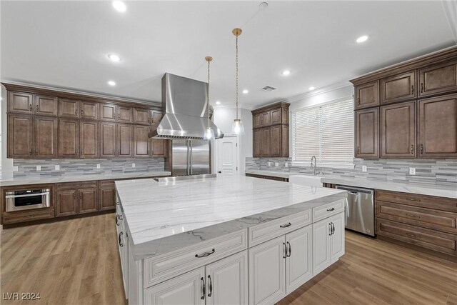 kitchen featuring ventilation hood, white cabinets, a spacious island, crown molding, and appliances with stainless steel finishes