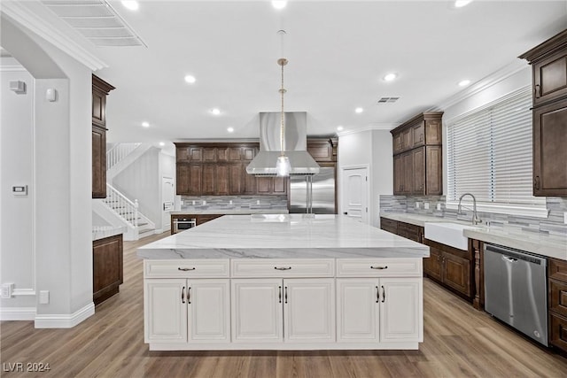 kitchen featuring stainless steel appliances, white cabinetry, dark brown cabinetry, a sink, and island range hood