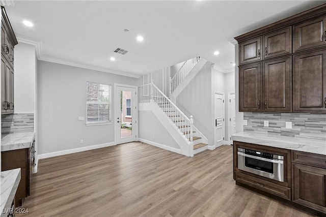 kitchen featuring decorative backsplash, light hardwood / wood-style flooring, and ornamental molding