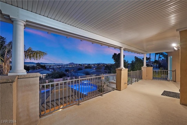 patio terrace at dusk featuring a balcony